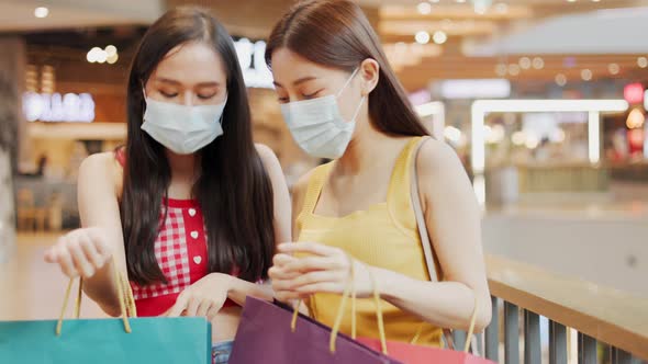 Asian woman wearing face mask. Happy woman with shopping bags enjoying in shopping