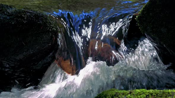 Closeup of River Between Stones in Forest - Detail of Flowing Water