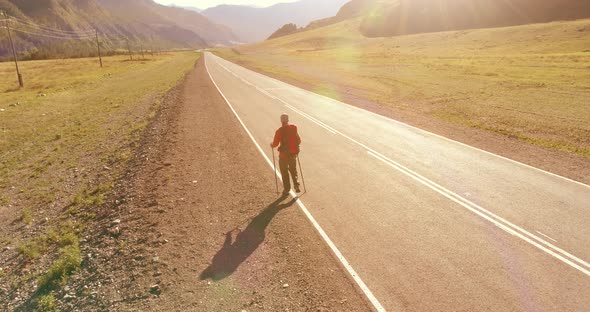 Flight Over Hitchhiker Tourist Walking on Asphalt Road