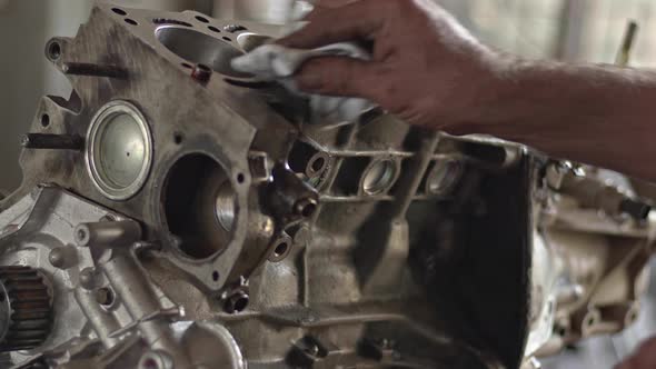 Car Mechanic Cleaning Engine Cylinder Block With Cloth During Repair