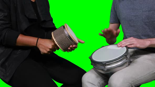 Mid section of musicians playing cabasa and drum