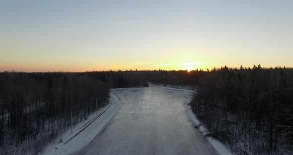 Aerial View of Winter Forest and Frozen River at Sunrise