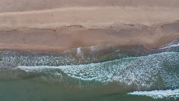 Drone flight above waves and sand