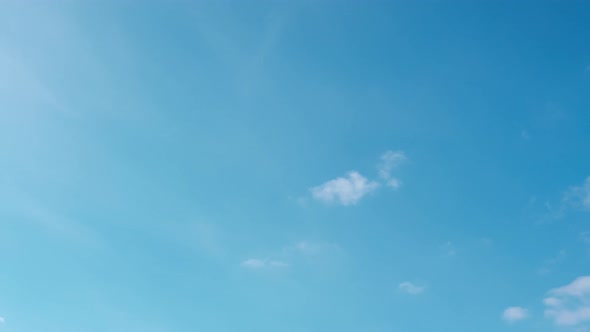 Clouds move in the blue sky.