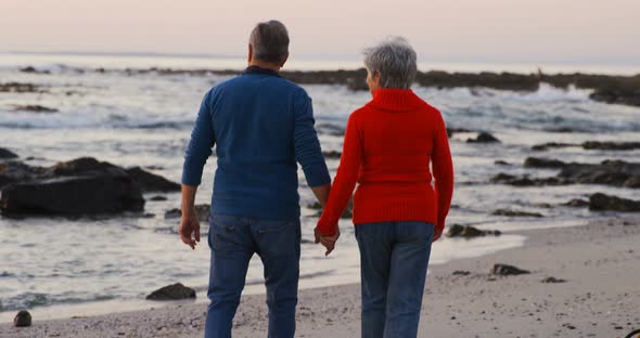 Senior couple walking hand in hand in the beach 4k