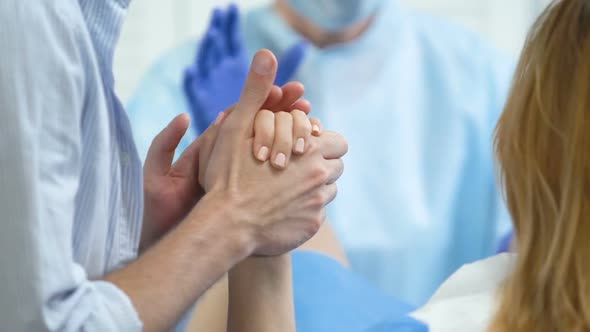 Caring Husband Holding Hand of Wife During Labor, Partner Support, Assistance