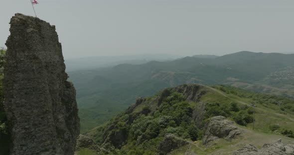 Revealing shot of the medieval Azeula Fortress and a fluttering Georgian flag.