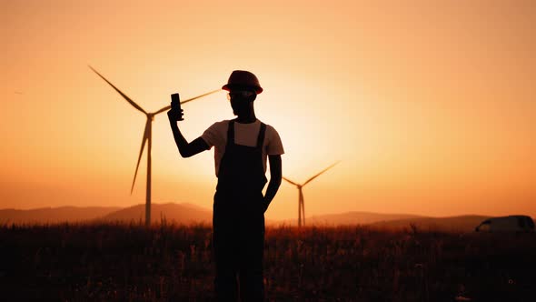 Silhouette Engineer in Uniform Using Modern Smartphone for Video Call Among