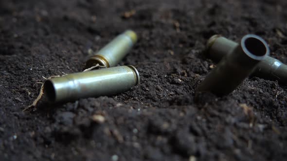 Bullet casings fall to the ground. Slow motion. alt