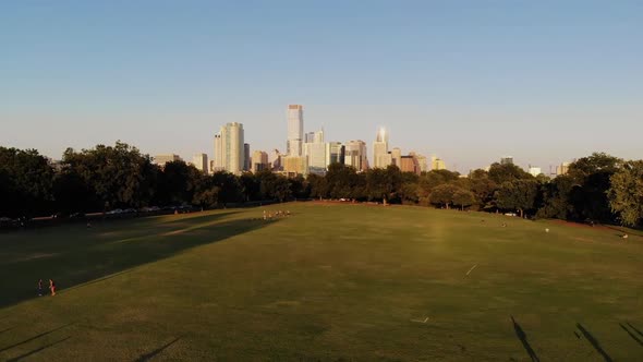 Aerial Drone shot from Zilker Park, going towards downtown Austin, Texas. People in zilker park play