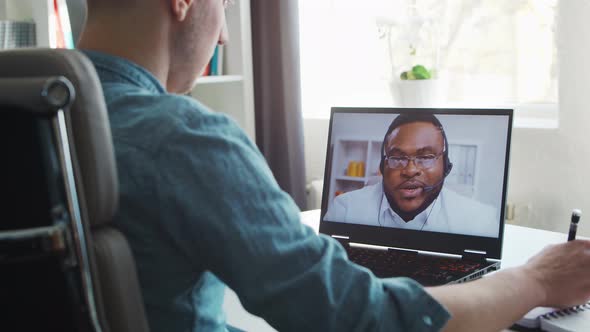 Young male entrepreneur works at home office at the computer.