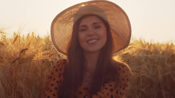 Pregnant woman in the rays of the sunset in the field