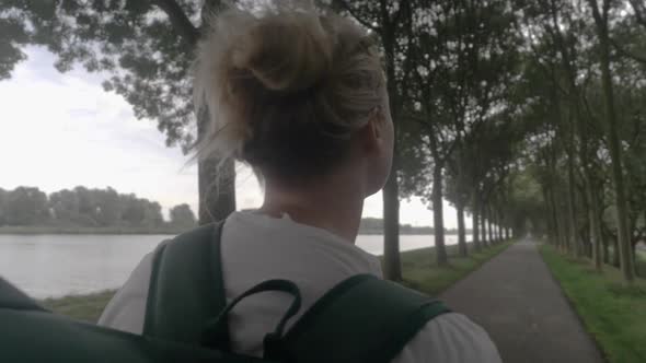 A Close up of a Young Woman Backpacker Admiring the Dutch Countryside