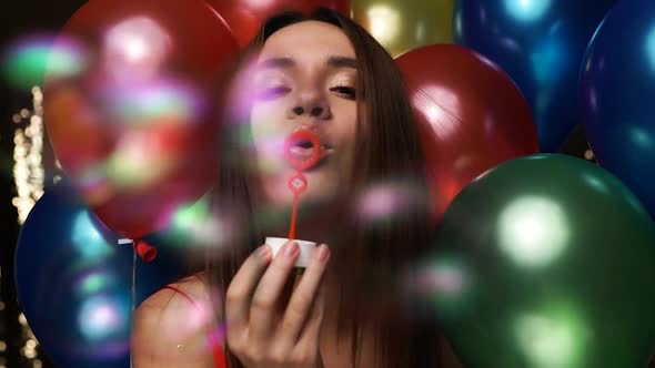Birthday Celebration. Woman Blowing Soap Bubbles With Balloons