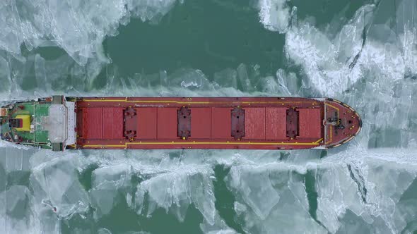 Aerial Above Epic Huge Steel Ship Breaks Ice By Bow of Ship and Floats in Large Sea Ice Floes