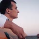 Alone Man Playing Guitar Sitting on the Coast - VideoHive Item for Sale