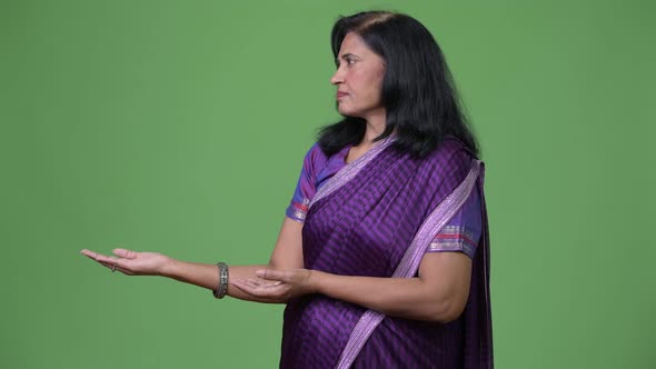 Mature Beautiful Indian Woman Showing Something While Wearing Sari Traditional Clothes