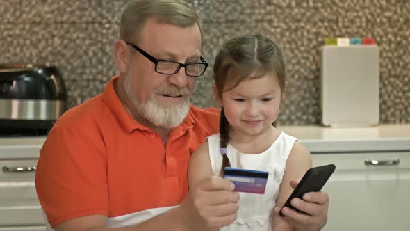 Grandfather and Granddaughter Choose a Gift for the Girl in the Online Store