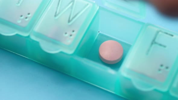 Close Up of Putting Pills and Capsule in a Pill Box