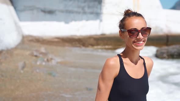 Slow Motion Slim Sexy Fitbody Smiling Young Woman in Black Swimwear Walking Along Sea Beach with