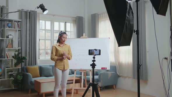 Asian Female Teacher With Marker Pen Shoots Video By Smartphone Camera While Teaching Math At Home