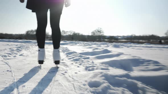 Woman is sliding along frozen ice on river