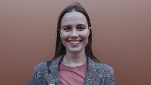 Young Adult Woman Dressed in Suit Smiling and Looking at Camera