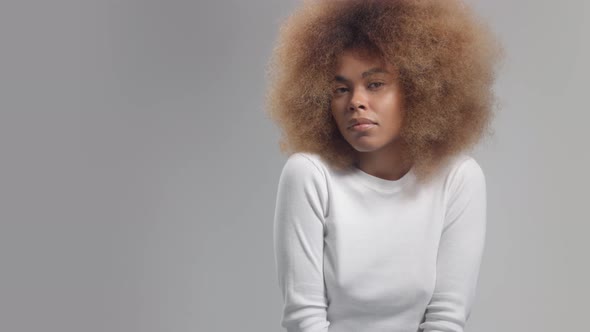 Panned Portrait of Mixed Race Black Woman in Studio Alone on Grey