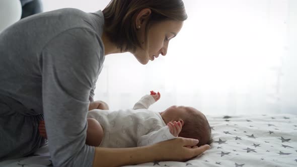 Beautiful Young Mother with a Baby Girl at Home