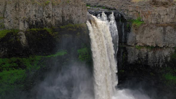 Cinematic Slow Motion Waterfall Cascading Over Canyon Cliff Edge Into Mist