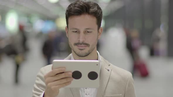 Lifestyle Portrait of Attractive Young Male Entrepreneur Browsing the Web Tablet Screen alt