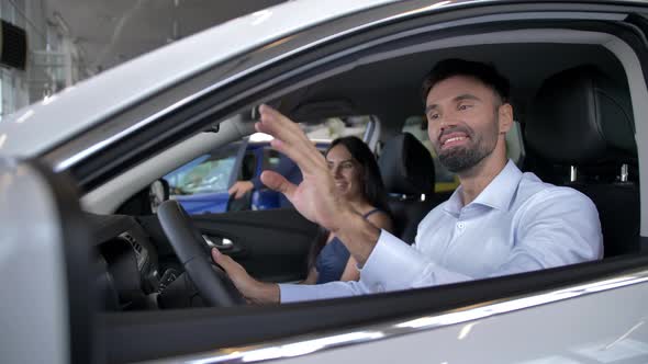 Joyful Couple of Buyers Sitting in Car at Showroom