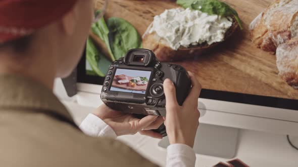 Female Food Photographer Scrolling Photos on Camera