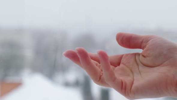 Slow Motion of Snow Falling Into Female Hand