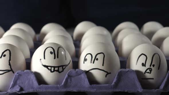 Four Faces Drawn on the White Eggs on the Tray