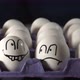 Four Faces Drawn on the White Eggs on the Tray - VideoHive Item for Sale