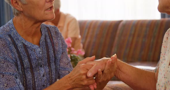 Happy senior friends holding hands and interacting with each other