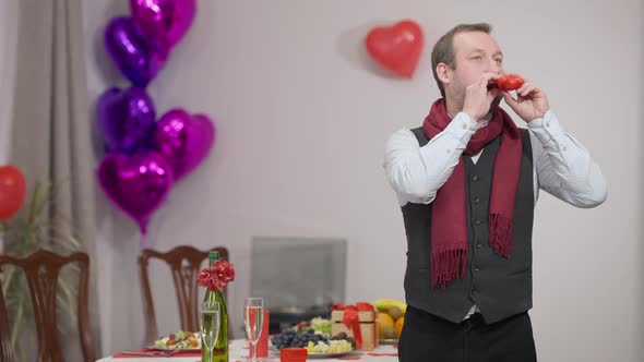 Middle Shot of Adult Caucasian Stylish Man Blowing Heart Shape Balloon Standing at Valentine's / Videohive