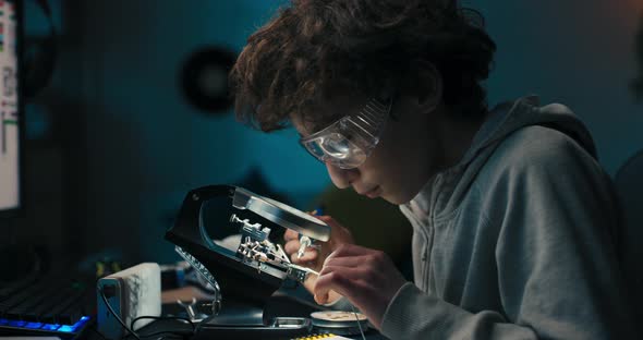 Child Spends Free Time at Desk Learning to Solder Cares About Safety Boy Has Safety Goggles Repairs