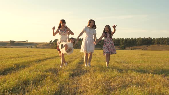 Concept of a Happy Family. Children and Mom Are Playing in the Meadow. Mother and Little Daughter