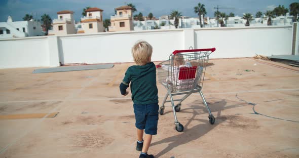 Kids Having Fun Playing with Supermarket Sopping Cart in Parking Outdoors