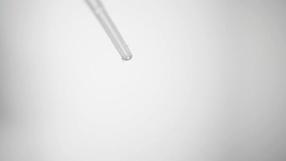 Lysis Buffer Drops From Tip Of Pipet With White Background. - close up shot