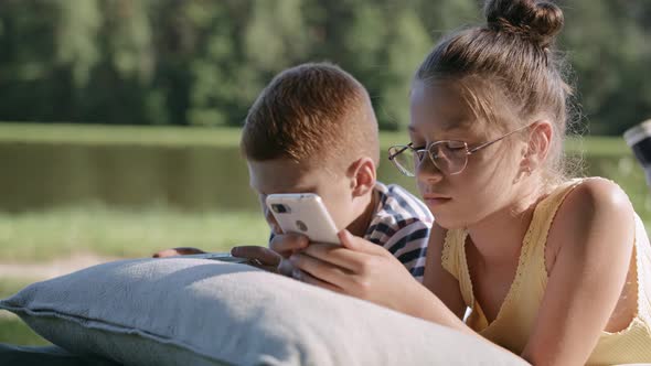 Video of children spending time with mobile phone on vacation. Shot with RED helium camera in 8K.