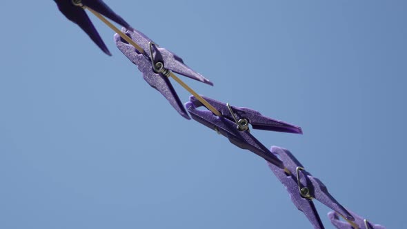 Close-up of plastic clothespins in a row  3840X2160 UHD video - Purple pegs on laundry drying line  
