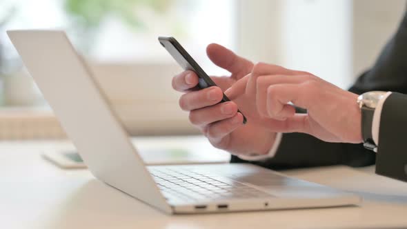 Close Up of Middle Aged Businessman Using Smartphone and Laptop