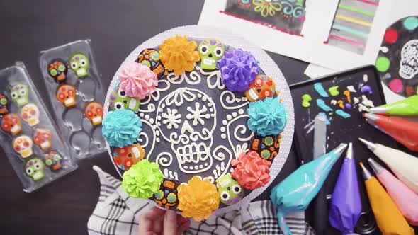 Step by step. Flat lay. Baker decorating multilayer chocolate cake with colorful italian buttercream