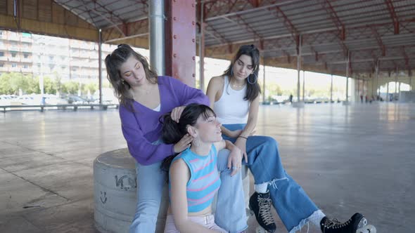 Roller Skater Girls in Colorful Clothes Sit Outdoors and Fix Hair