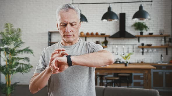 Aged Athletic Male is Setting Timer on Smartwatch Gadget and Holding Breath During Breathing