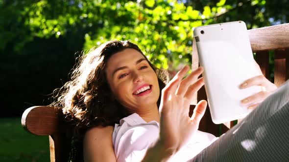 Beautiful woman using digital tablet in garden