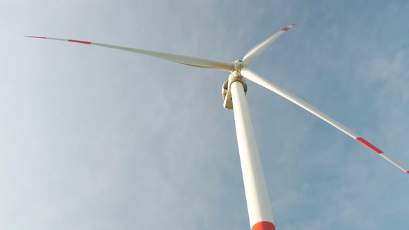 Tall Wind Turbine Spinning Against the Cloudy Sky